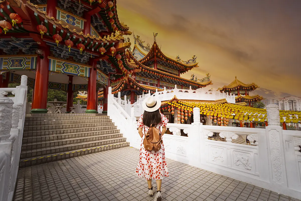 Tourist exploring Thean Hou Temple in Kuala Tourist exploring Thean Hou Temple in Kuala Lumpur, Malaysia, during sunset, showcasing vibrant architecture and cultural beauty, perfect for budget travel in Malaysia.